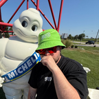 Spotto wearing terry towel bucket hat in front of the Michelin man at the corvette museum in the USA